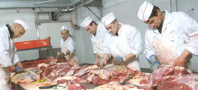 Les bouchers de Boucherie Dynamique qui travaillent la viande à l'atelier